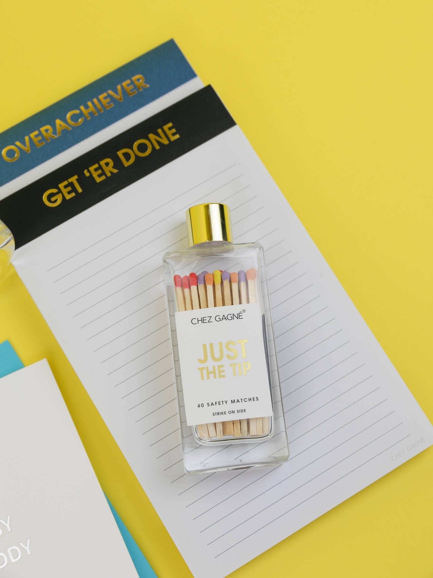 Rainbow tipped match bottle styled with yellow stationery and gold foil notes