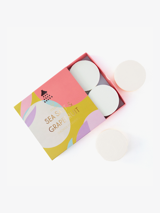 Open drawer box revealing two white grapefruit shower steamers inside packaging