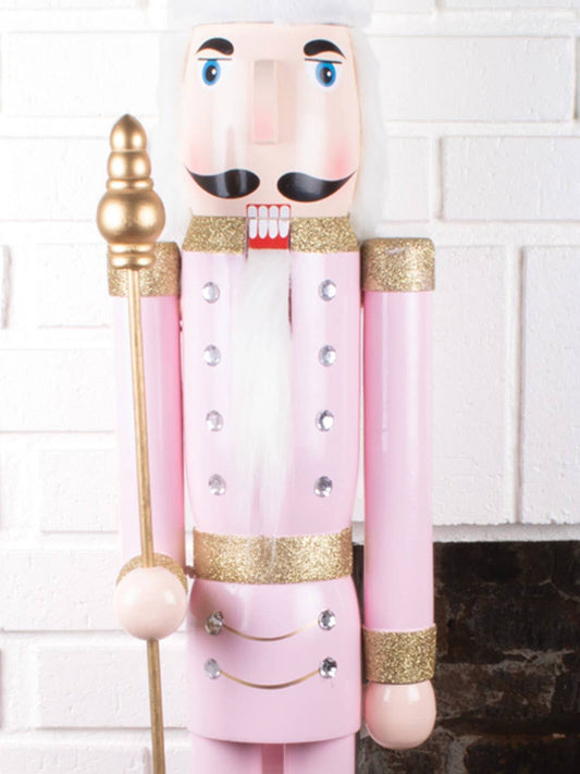 Pink wooden nutcracker soldier with gold glitter trim and rhinestone buttons