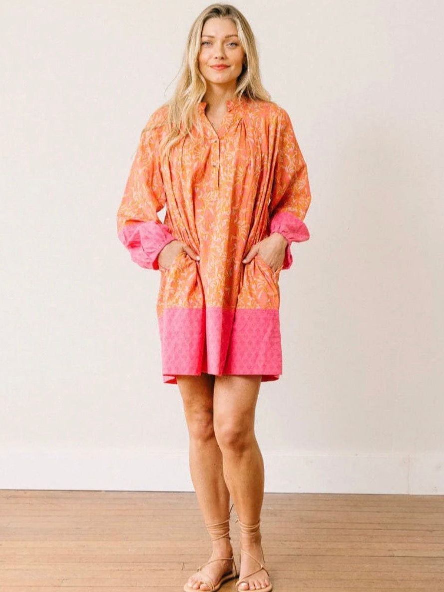 Orange folk floral mini dress with pink geometric cuffs and side pockets