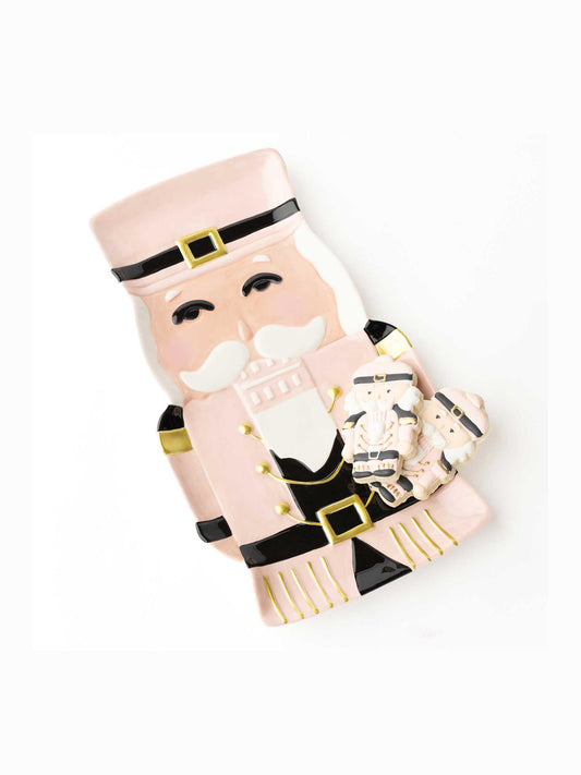 Pink ceramic nutcracker serving platter holding cookies showing gold buckle belt detail