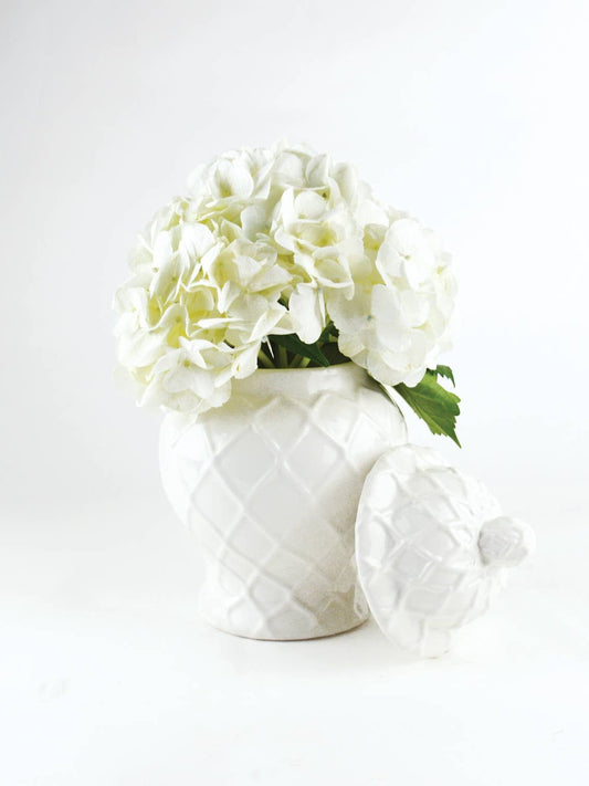 White textured ginger jar holding white hydrangea bouquet