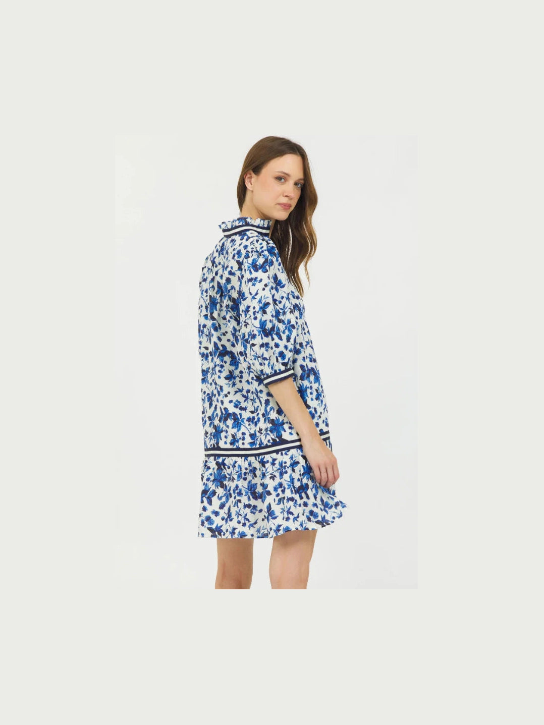 Side view of white floral mini dress showing puff sleeve volume and ruffle hem