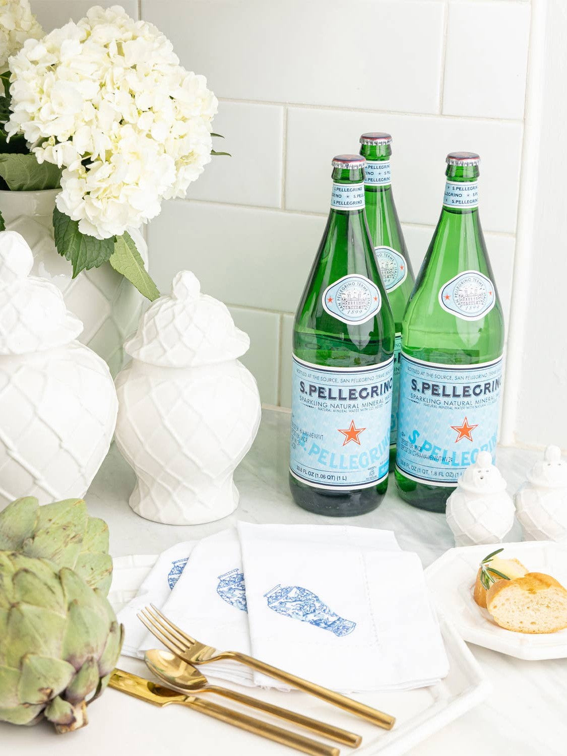 White quilted ginger jar styled with sparkling water and table setting
