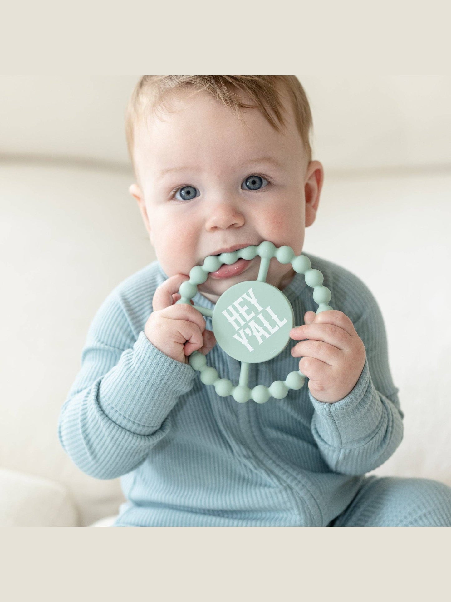 Sage green silicone teether with beaded rim and 'HEY Y'ALL' text